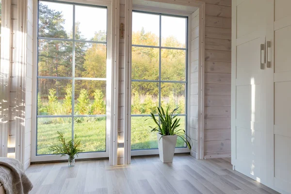 Large floor-to-ceiling grid-style windows in a modern wooden interior