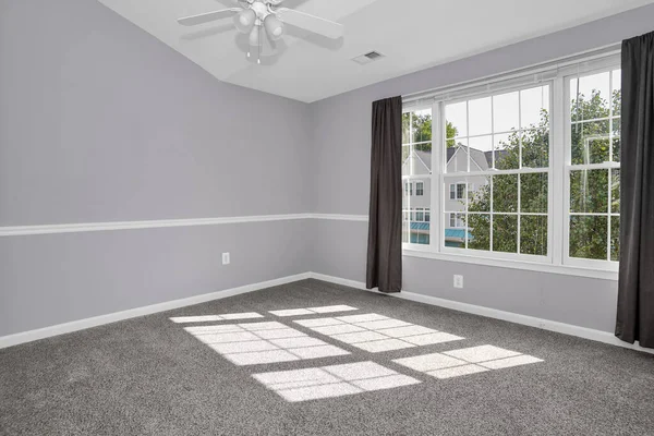 Large white grid-style vinyl windows in an empty modern room, allowing abundant natural light