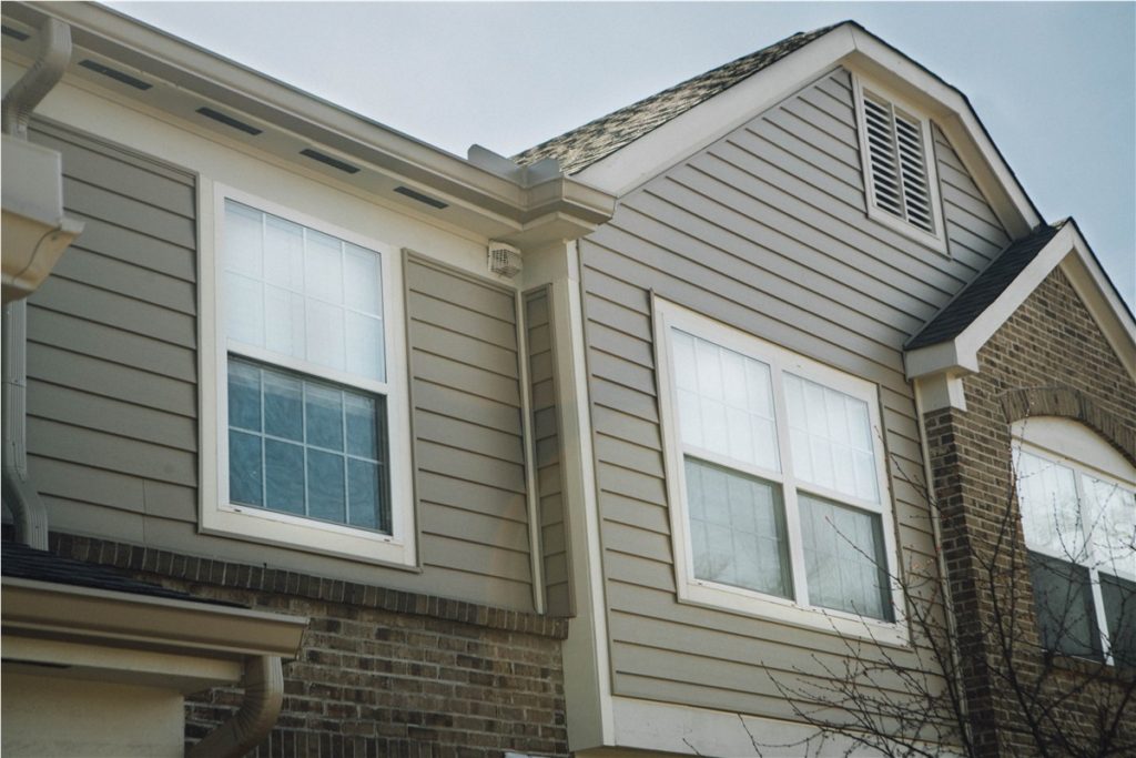 Exterior view of a house featuring two white double-hung windows with clear glass