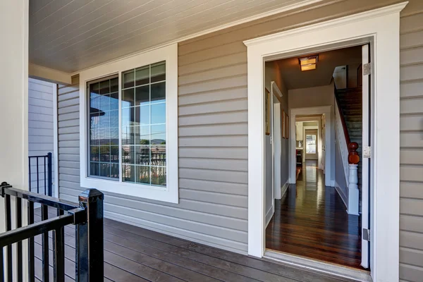 White-framed sliding window with grid design, installed on a beige vinyl-sided home