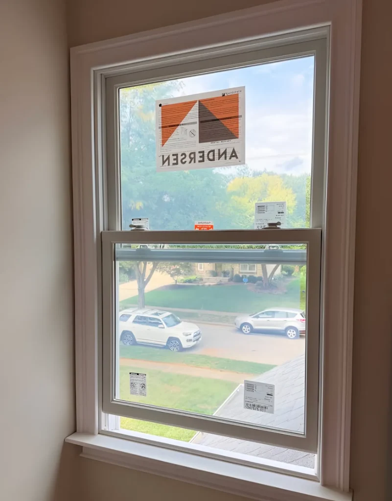 Interior view of a new double-hung window with a manufacturer label on the glass